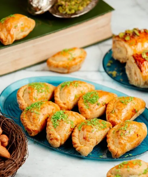 side view of oriental pastry with nuts and pistachio on a platter